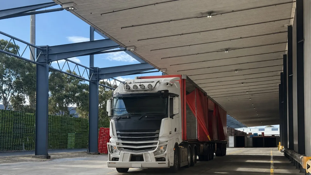 Unbranded heavy commercial vehicle parked at a covered loading bay.